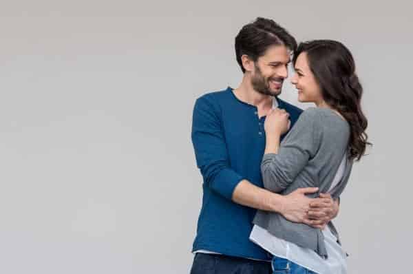 Man with his arms around woman's waist, smiling at each other representing The Big Secret to a Happy marriage