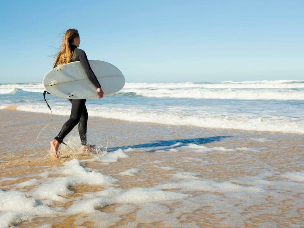 Woman surfing at the beach. how to get over your ex.