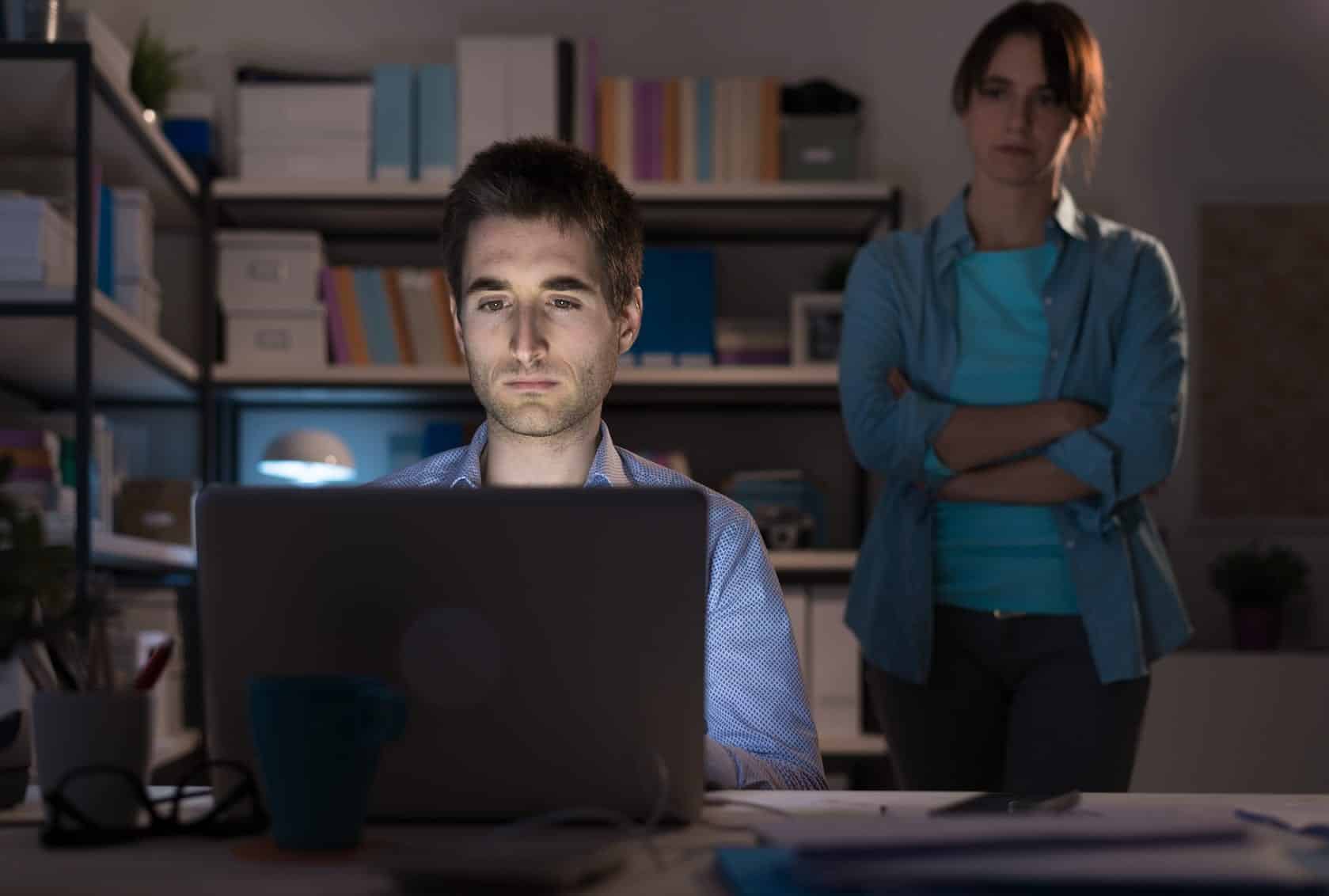 Man on computer with woman staring over shoulder. Protect Your Relationship From online infidelity.