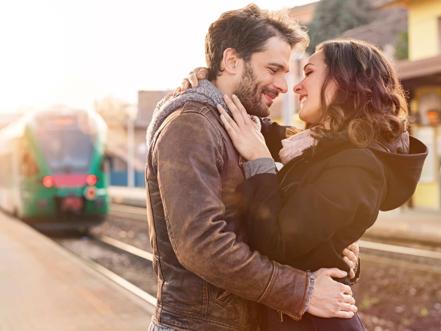 Couple embracing at the train station representing How To Create A Great Online Dating Profile