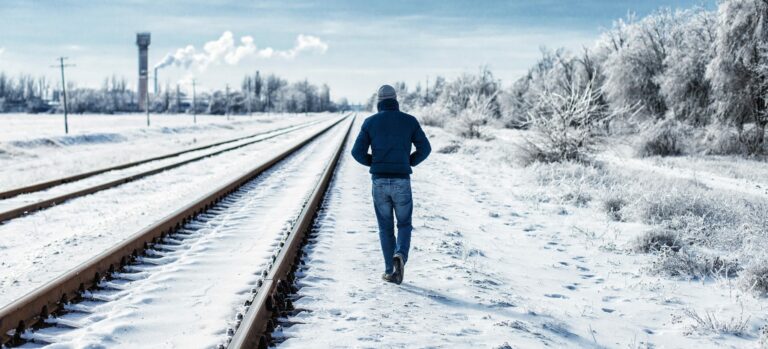 man walking through snow coping with a breakup over the holidays