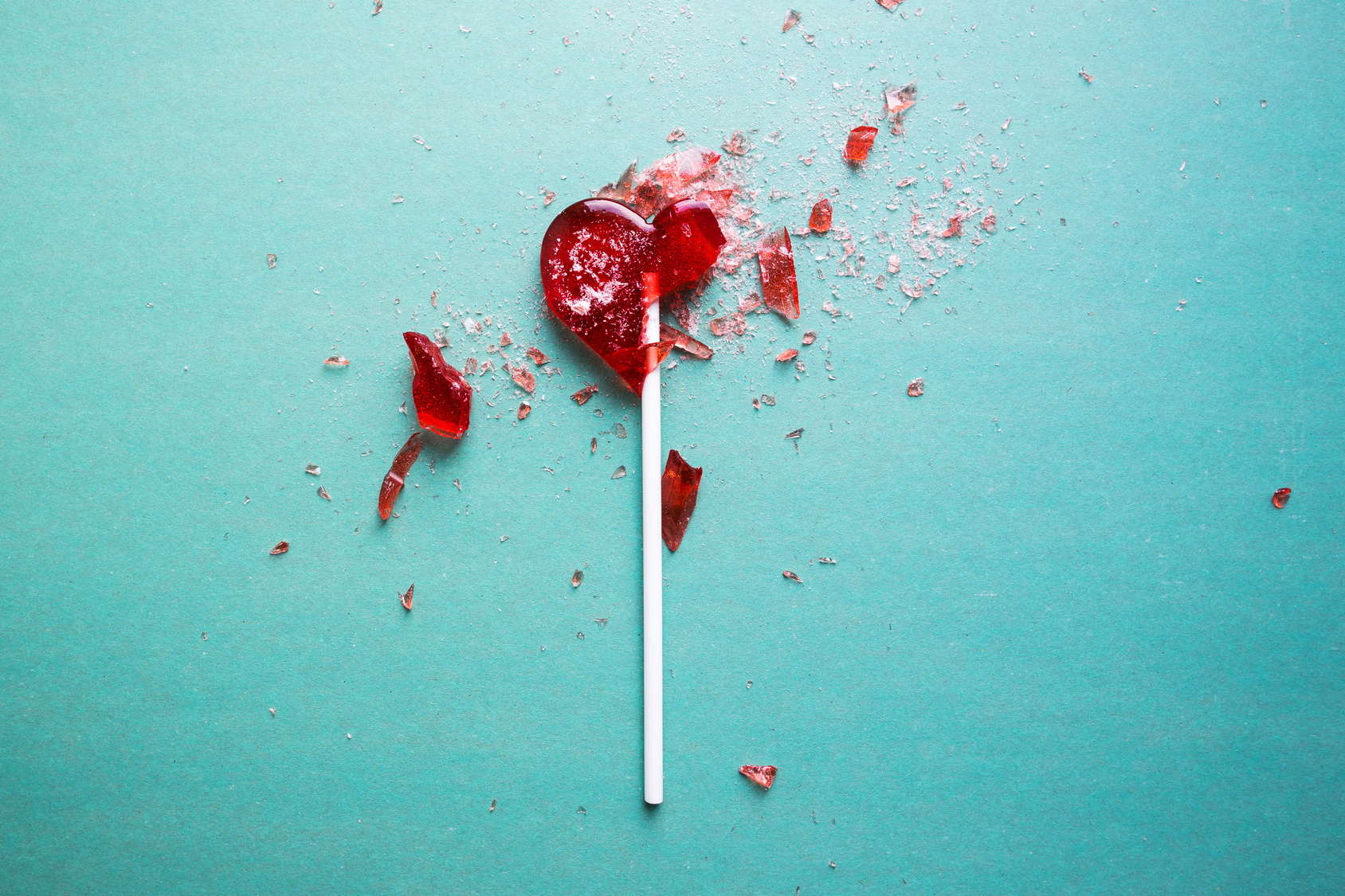 Heart lollipop cracked and broken on the floor. How to get over a breakup.