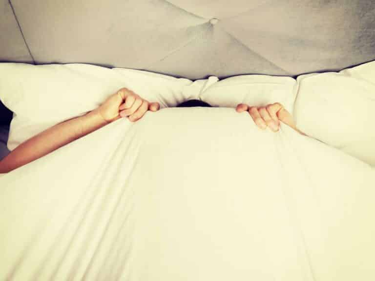Person in bed pulling cover on top of the head representing When Your Wife or Husband Refuses to go to Marriage Counseling.