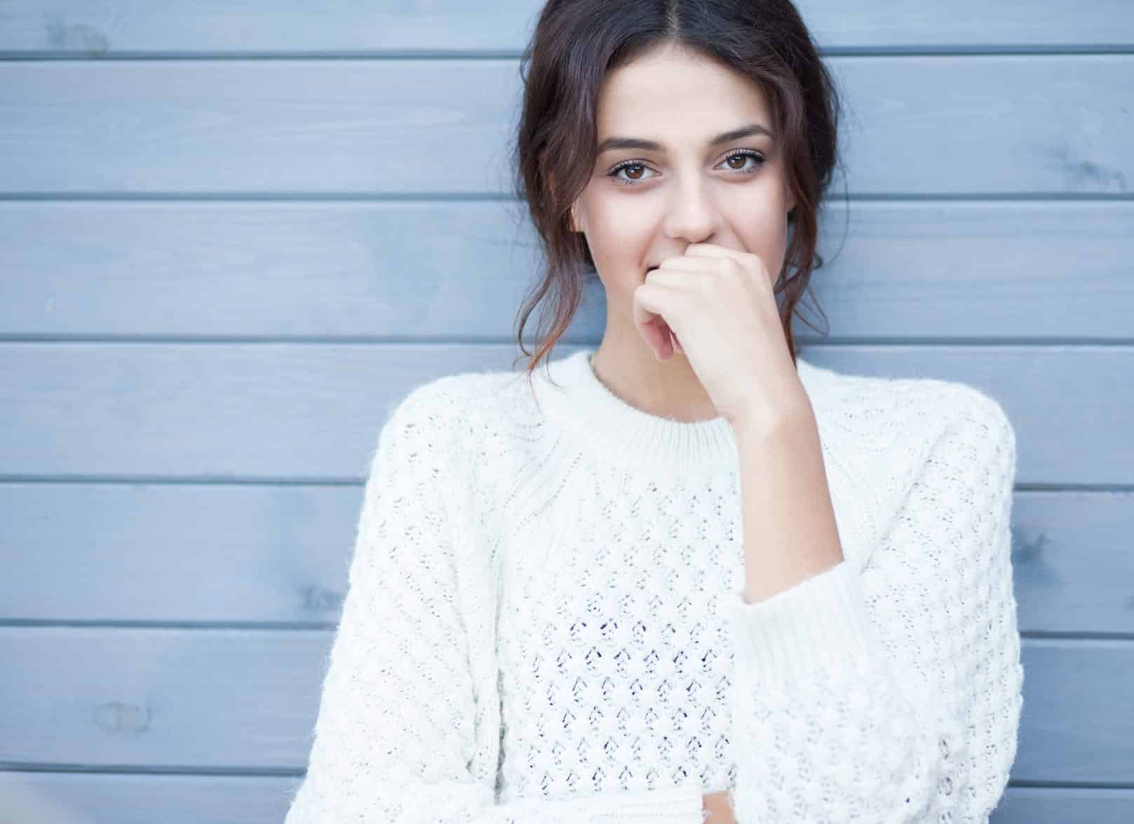 Woman standing against a wall. The surprising key to finding love.