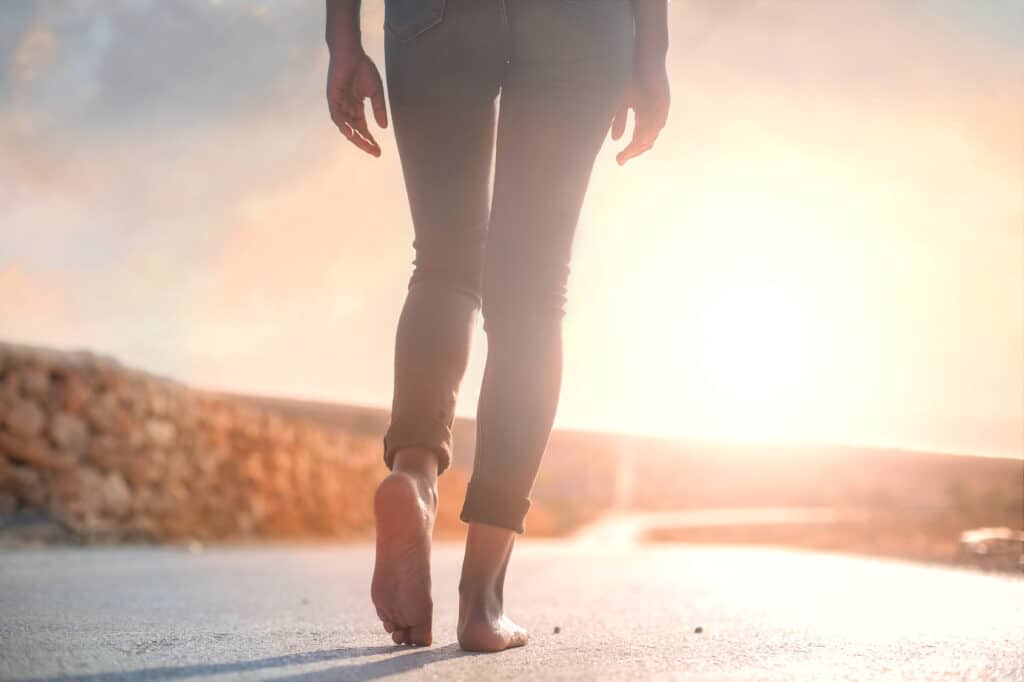 Woman walking barefoot on the pavement experiencing post traumatic growth