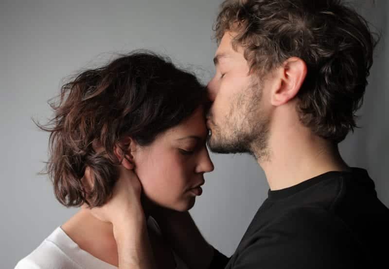 Man kissing woman on forehead as they both grow through relationship fights.