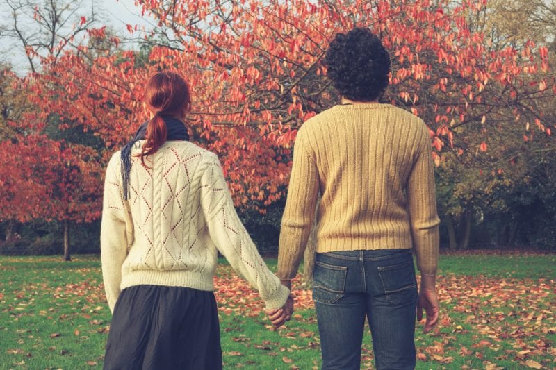 Couple standing next to each other, facing pretty trees wanting real relationship advice and the key to a healthy, happy marriage