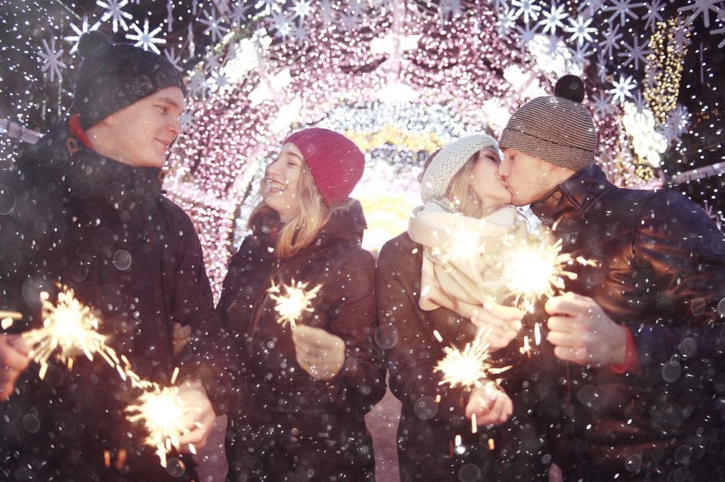 couple dating during the holidays with sparklers in hand