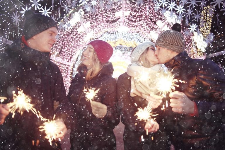 couple dating during the holidays with sparklers in hand