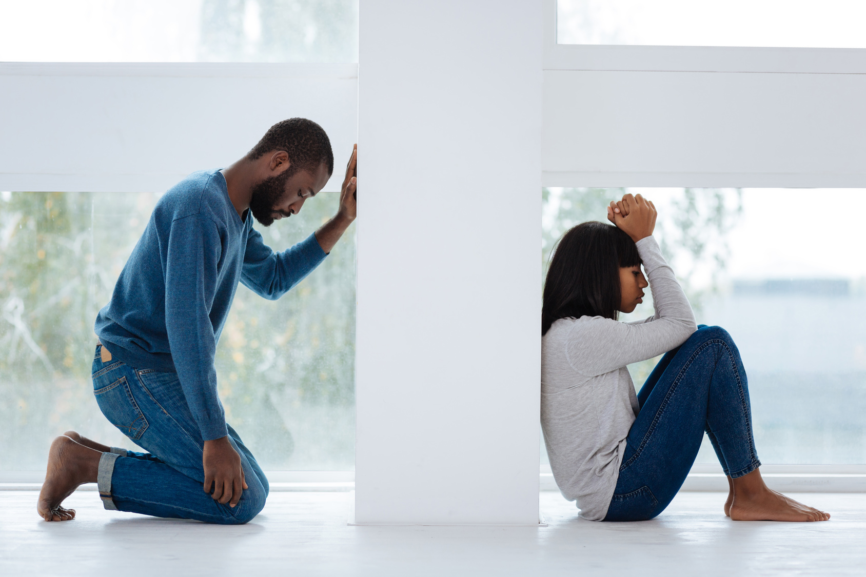 Couple on opposite sides of a wall. How to forgive your partner when the hurt feels big.