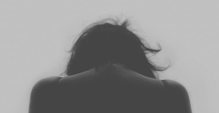Silhouette of woman with back facing camera black and white representing How to Deal with the Winter Blues