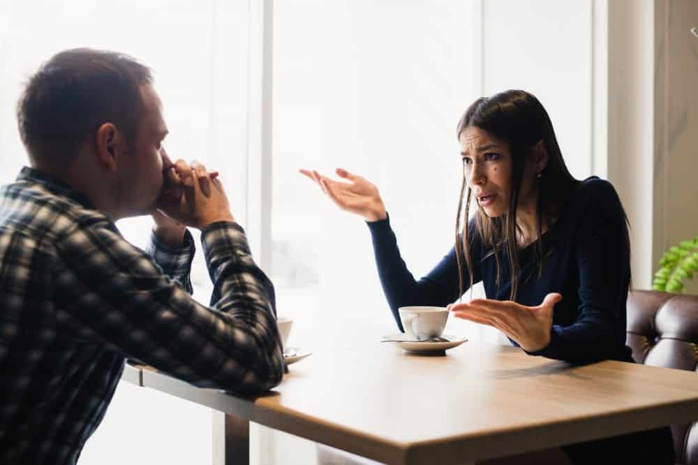 Couple sitting at dining table learning how to argue effectively