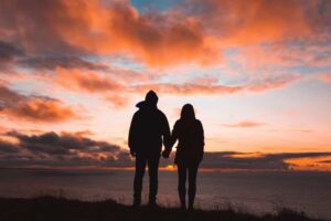 Man and woman holding hands staring off into the sunset representing How To Heal Your Relationship After An Affair