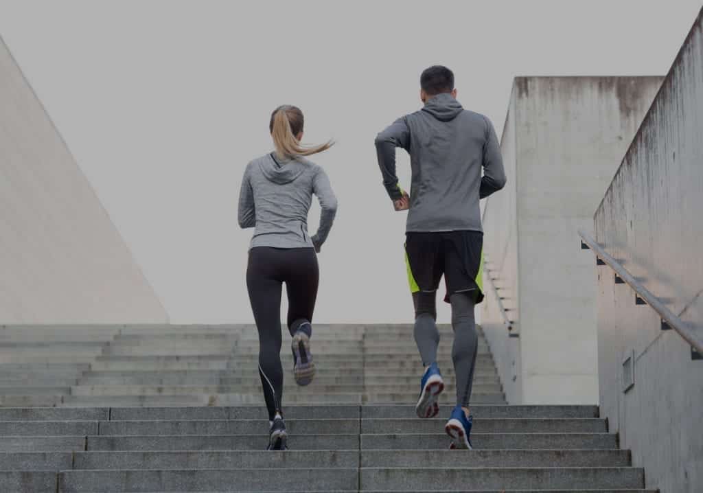 Couple running up stairs working to keep on track with new years goals