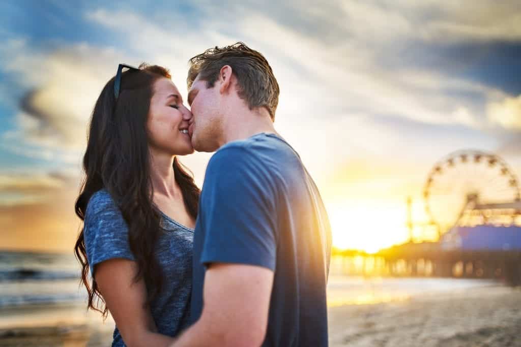 Couple kissing at the beach wondering why is dating so hard?