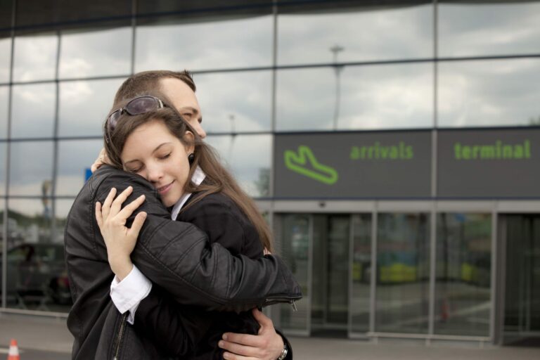 Couple hugging at airport learning How to make long distance work.