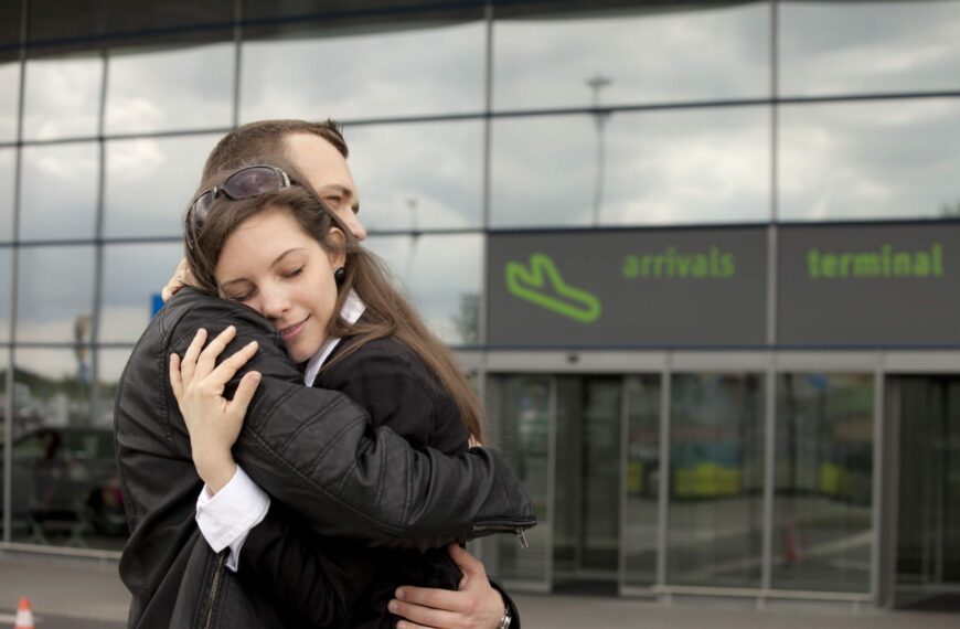 Couple hugging at airport learning How to make long distance work.