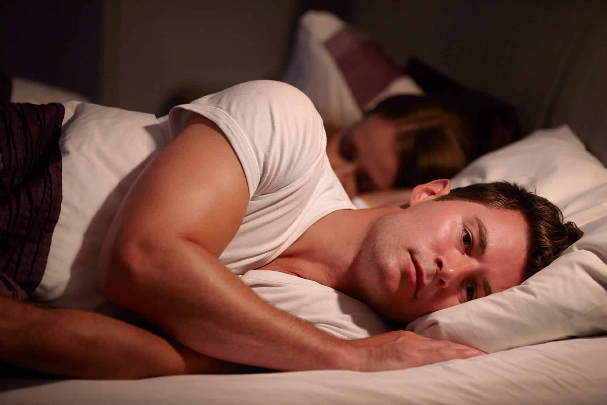 man in bed unable to sleep wanting tips to manage stress