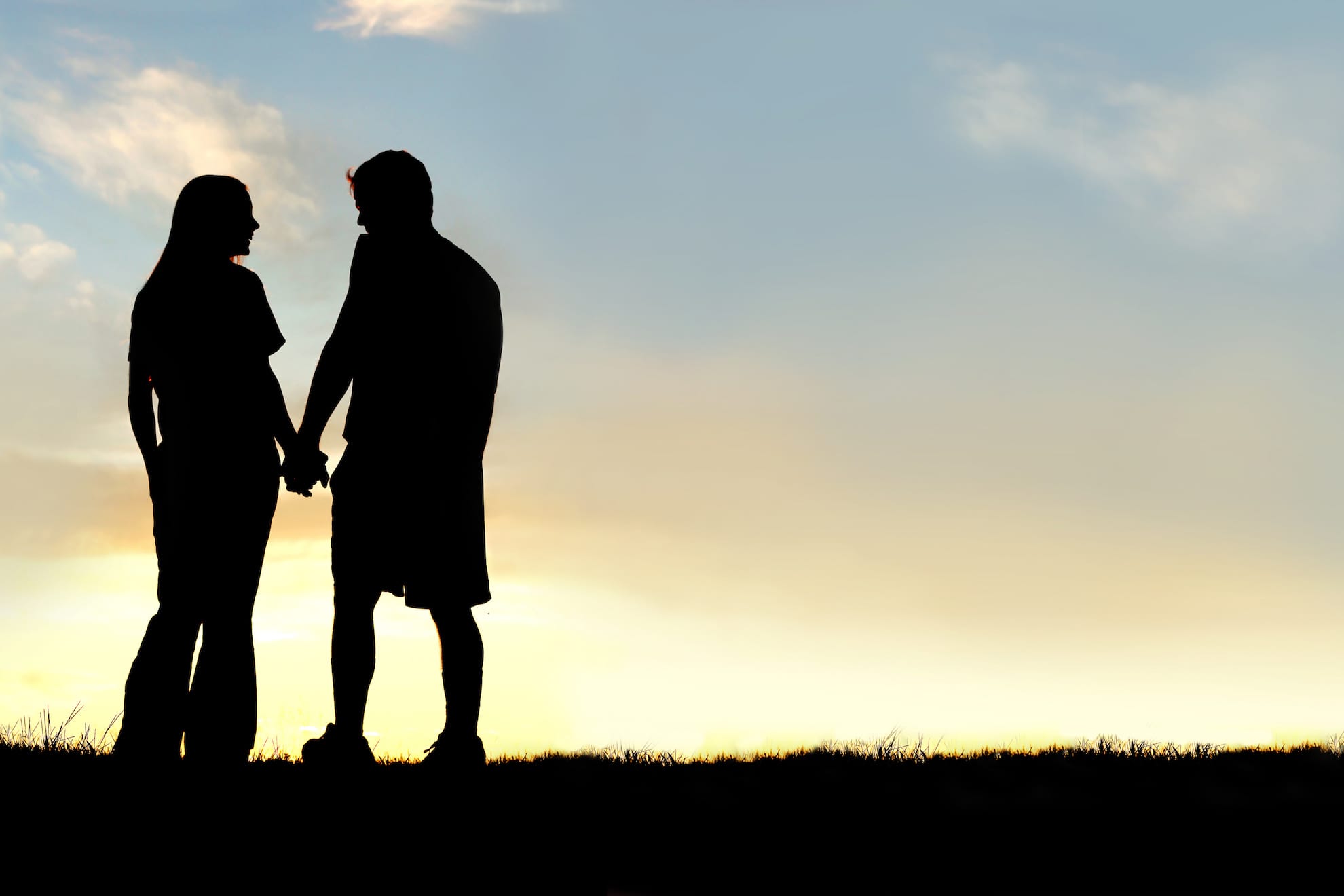 couple holding hands at sunset discussing 4 common relationship issues