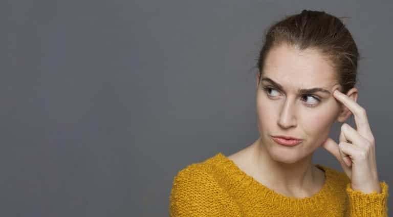 Woman looking sideways with her lips pursed. Overly High Expectations of Relationship.
