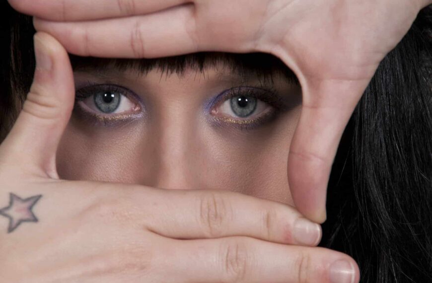 Face hiding behind hands representing How to Be More Vulnerable in Relationships