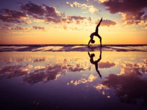 Person doing a backbend on the water practicing self love