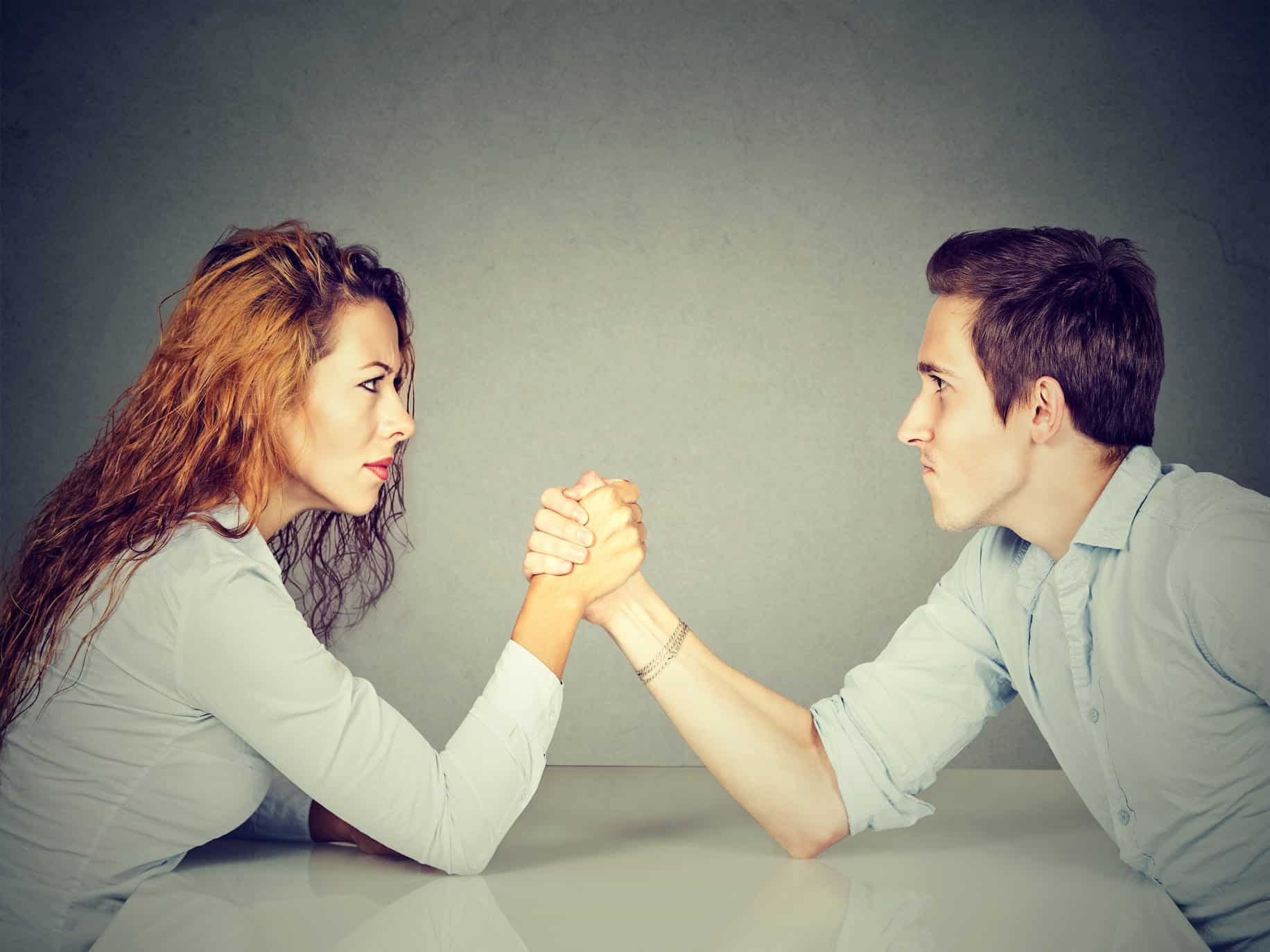 Couple arm wrestling representing having the same fight over and over.