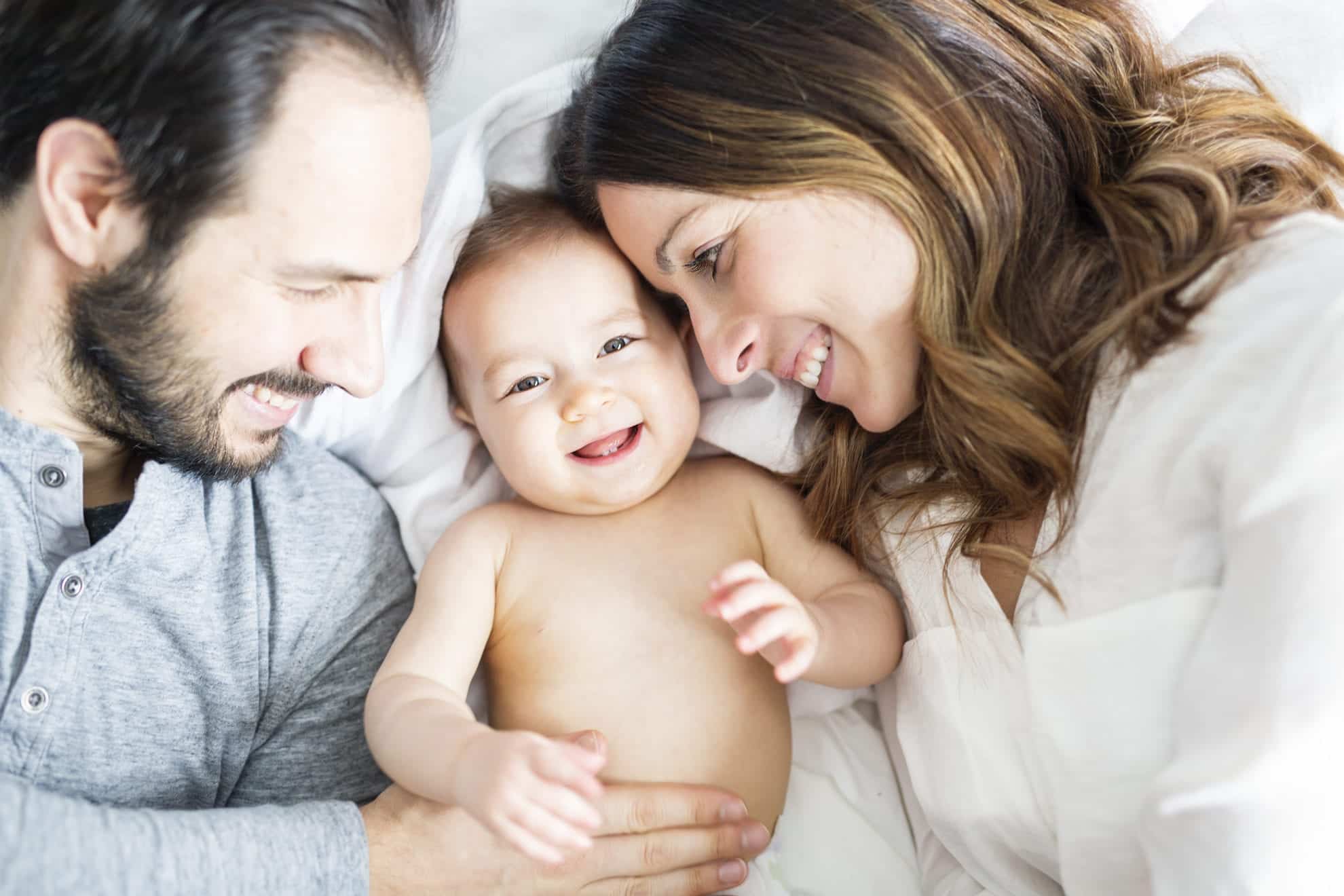 Happy couple looking at infant Prepare Your Relationship after Baby