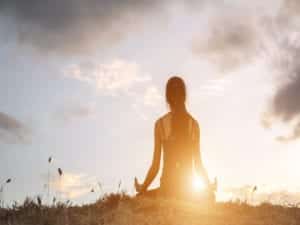 Woman meditating outside practicing Mindful Self Compassion