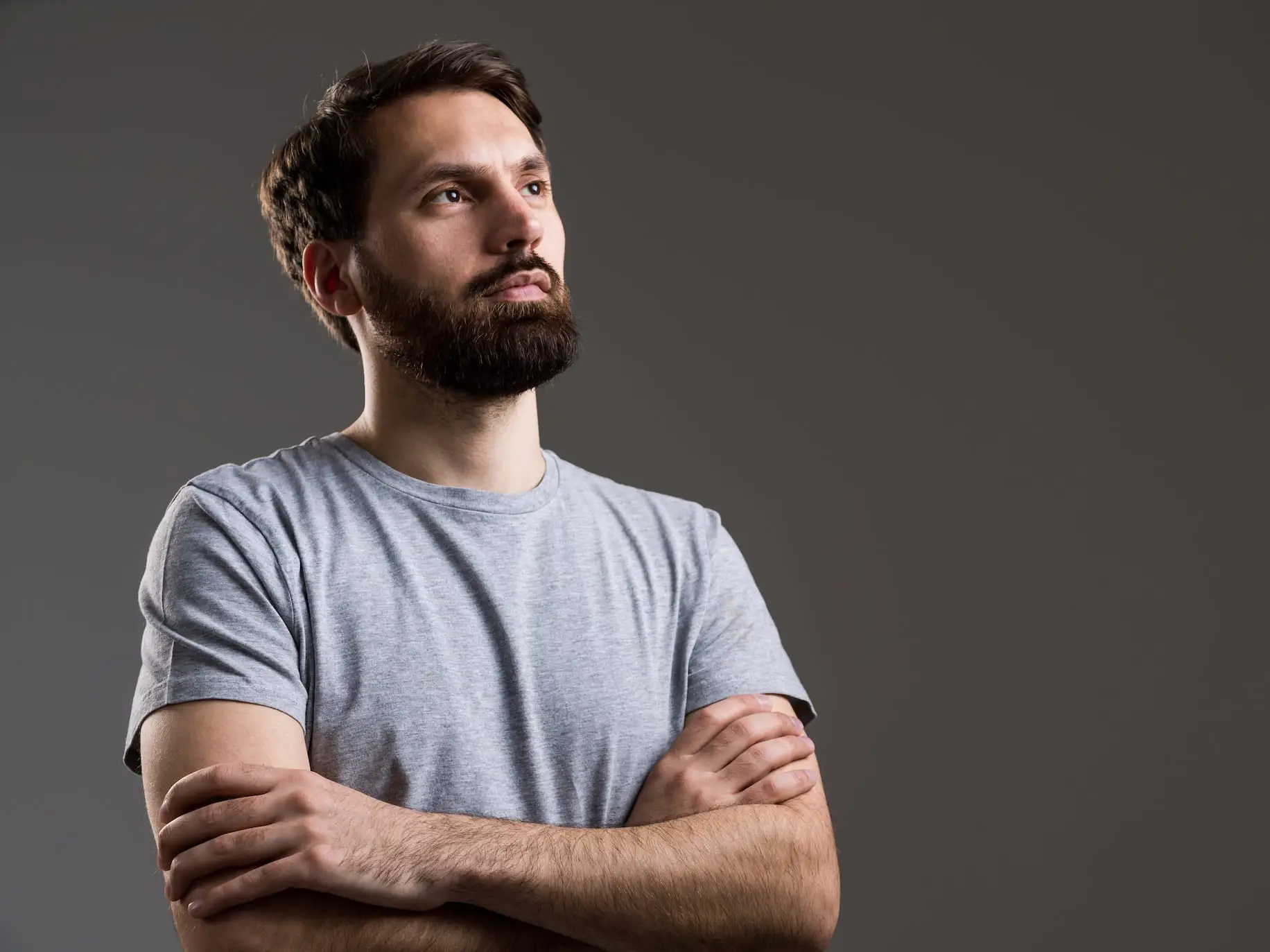 man standing with arms crossed feeling invalidated by his partner