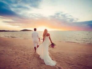 Couple in wedding attire on the beach knowing that premarital counseling was worth it