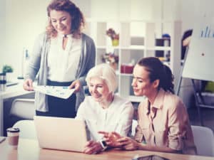 Older woman working with two younger women. Generational Differences in the Workplace.