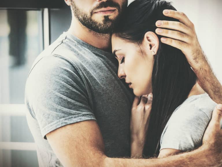Man holding woman tenderly. How to break up with someone you love.