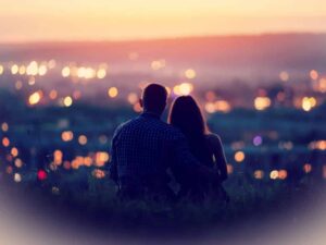 Couple sitting and looking out over a lovely view below representing How to find true love.