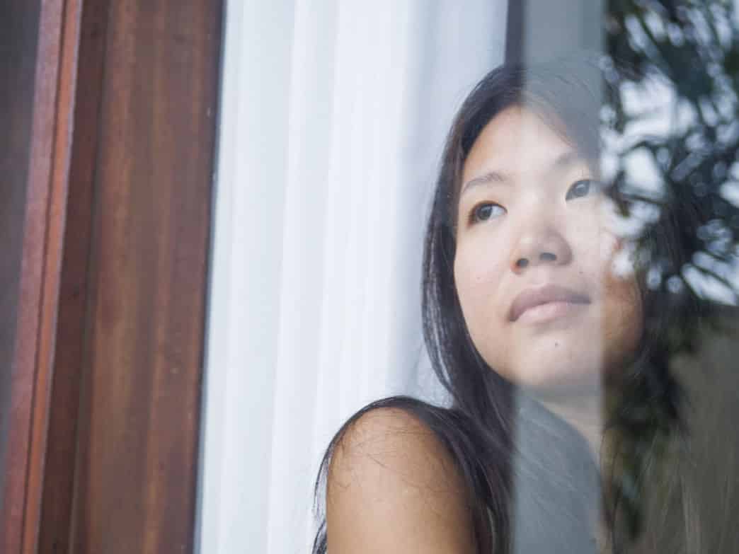 Woman looking out in the distance, sad. Healing after loss.