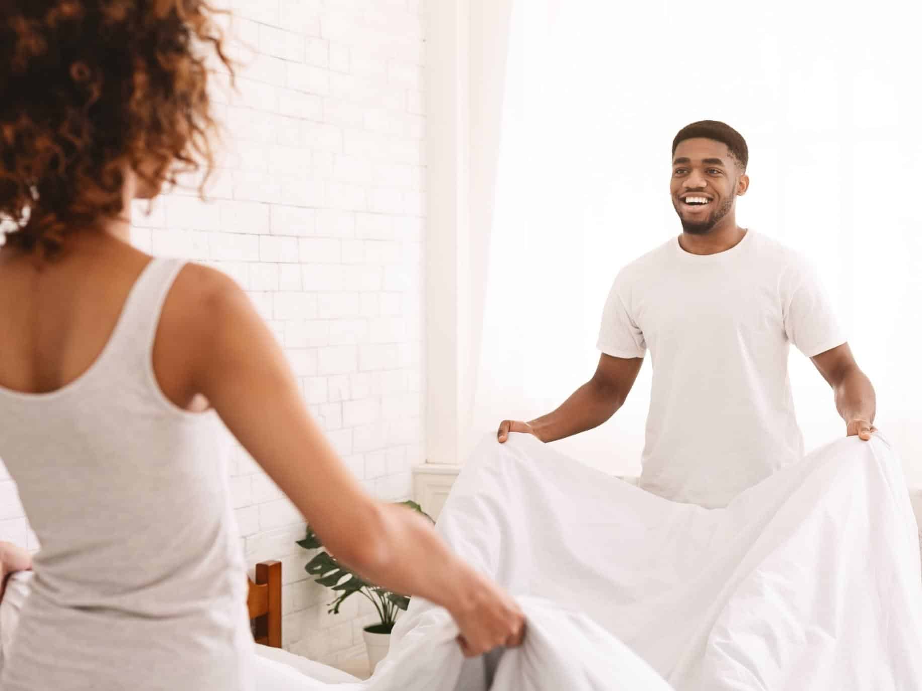 Couple making the bed. Egalitarian Relationship.