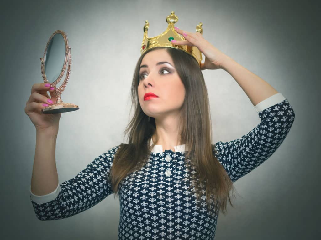 Woman with a crown, looking at herself in a mirror. how to deal with selfish people