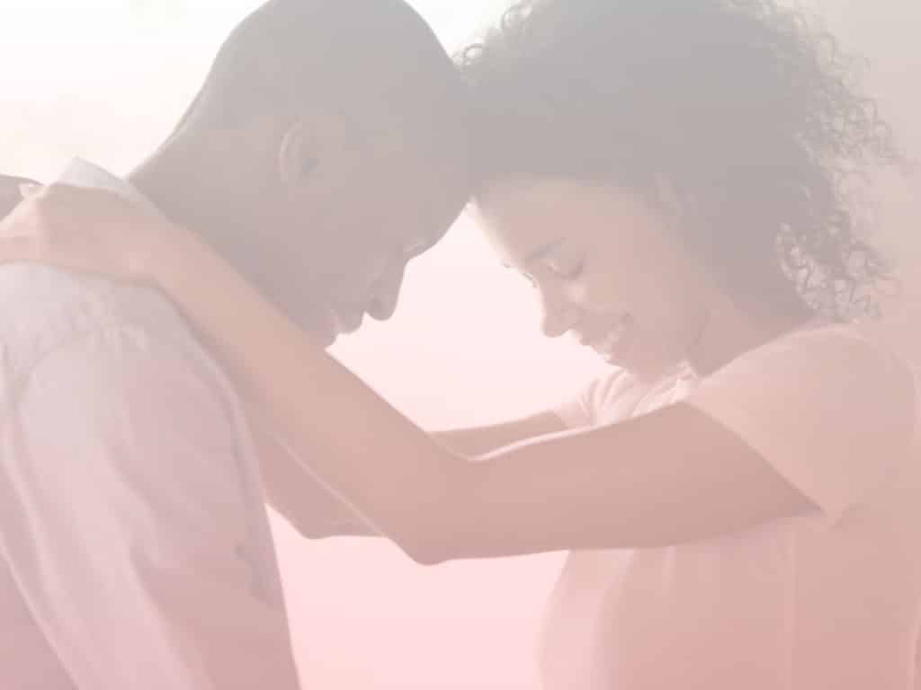 Man and woman standing with their heads against each other. Woman's arms on man's shoulder. How to Fix Your Relationship After a Fight.