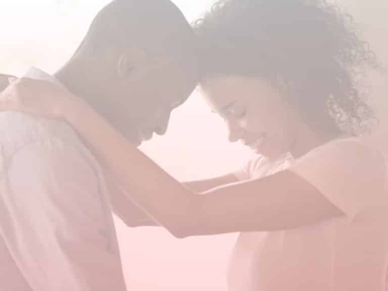Man and woman standing with their heads against each other. Woman's arms on man's shoulder. How to Fix Your Relationship After a Fight.