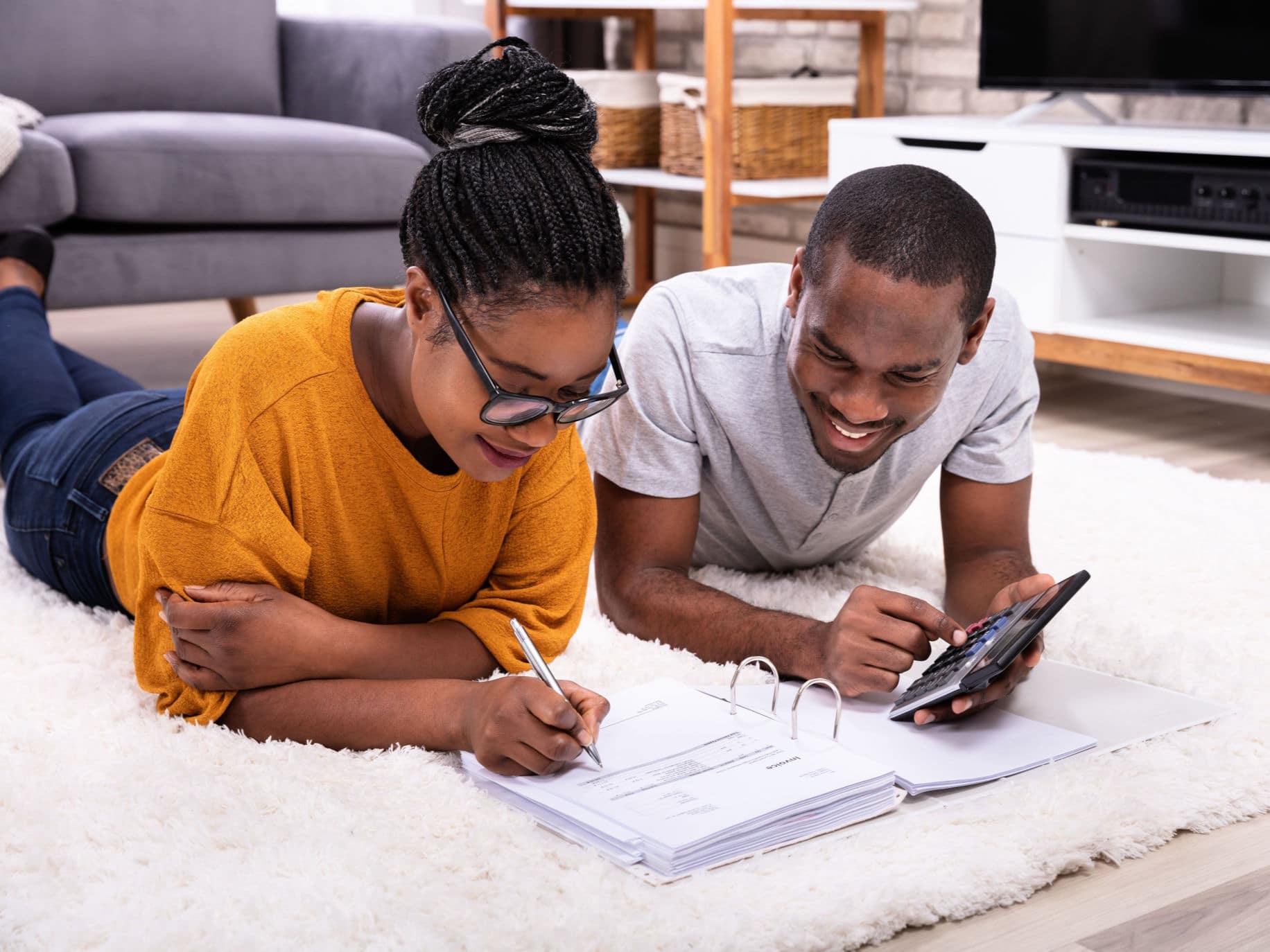 Couple on floor figuring out finances representing Financial counseling for couples.