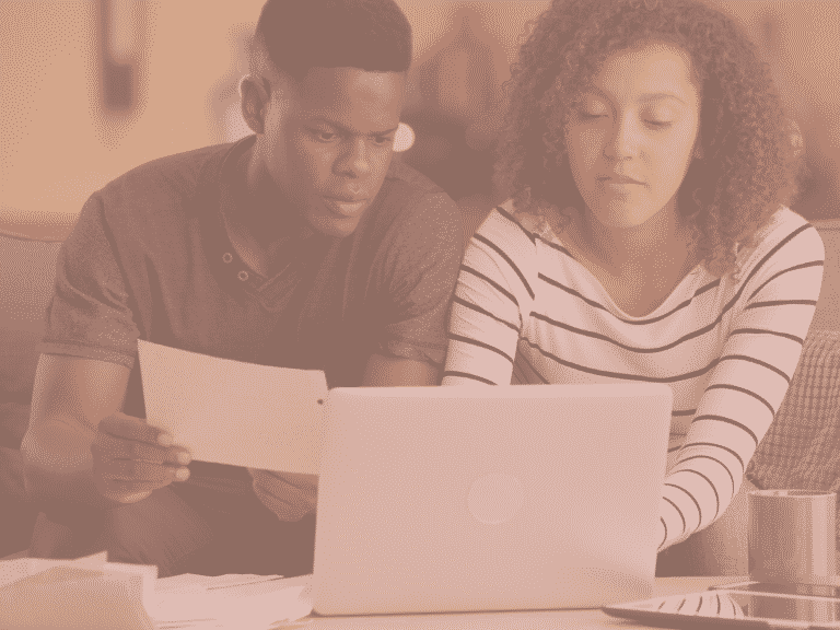 Couple looking at their finances representing: Should married couples merge finances?