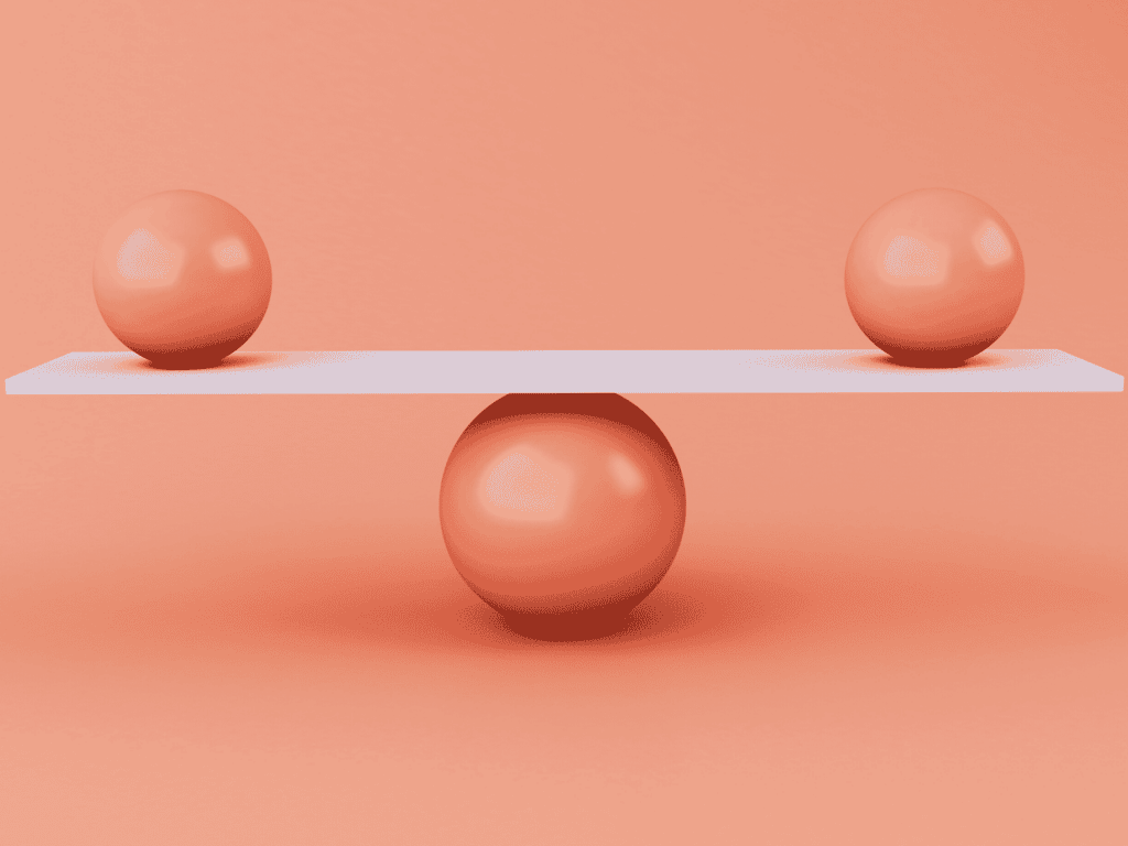 two smaller balls balancing on top of a bigger ball. finding balance.