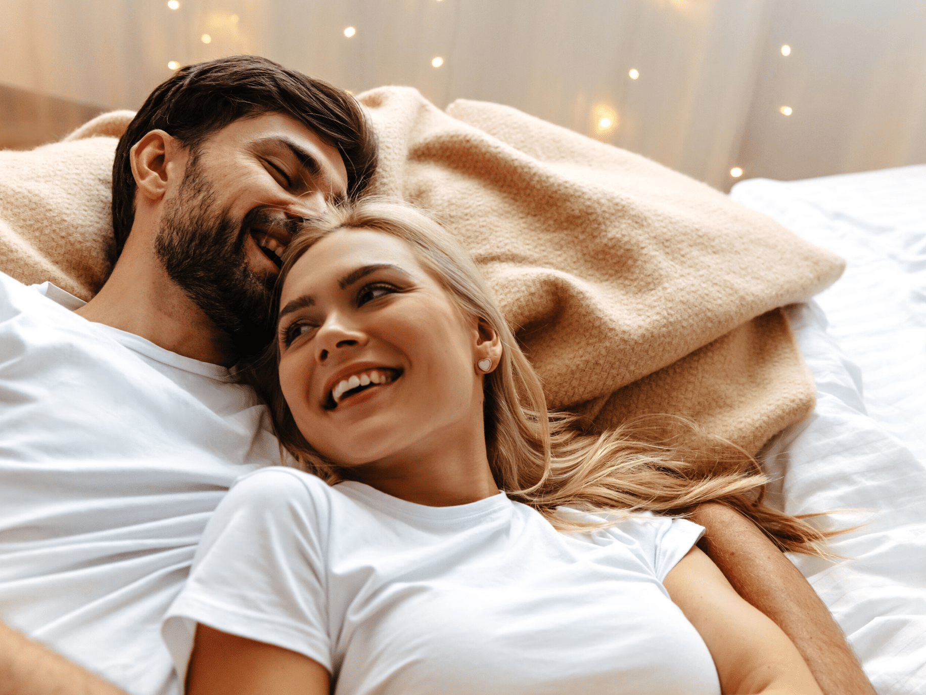 Happy couple lying in bed representing Keys to a Successful Marriage