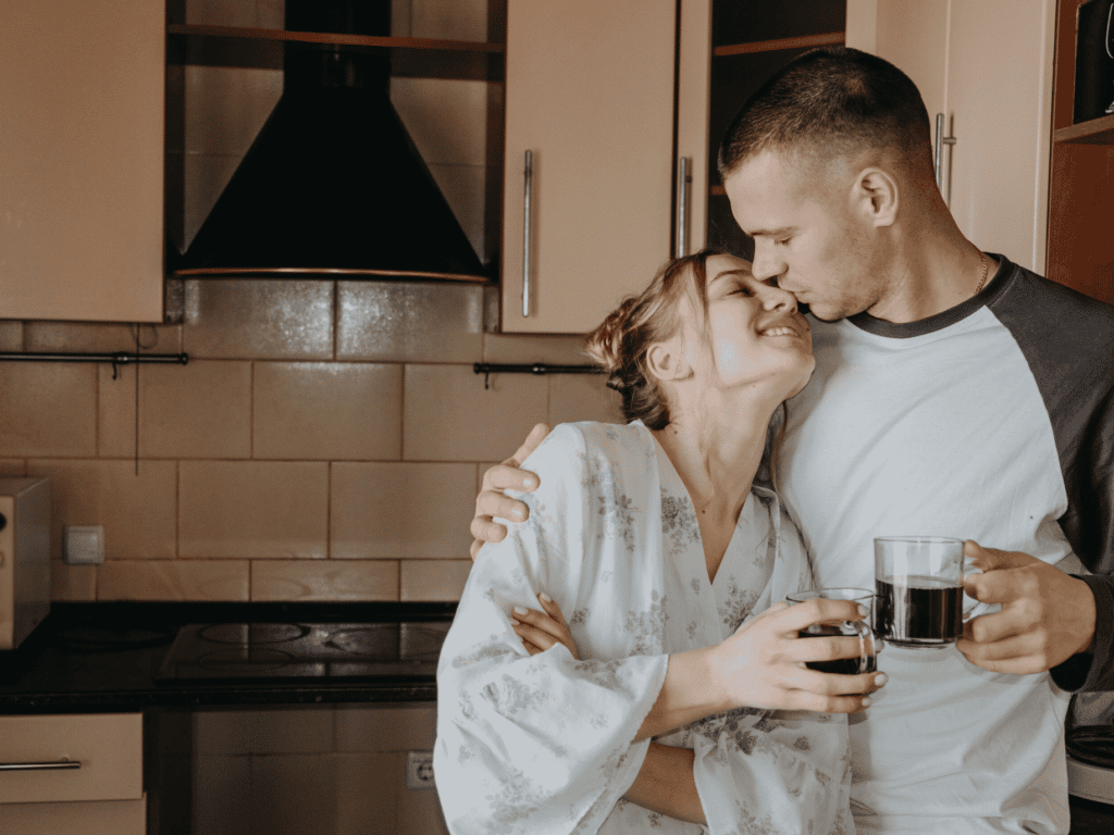 Couple in kitchen about to kiss. protect your relationship in times of stress.