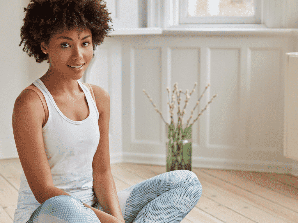 Woman sitting in a room on the floor learning how to love yourself.