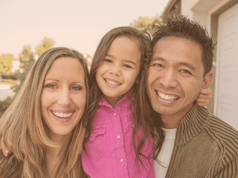 Mother, father, and daughter in the middle, all smiling representing Love without Borders: Cross-Cultural Relationships