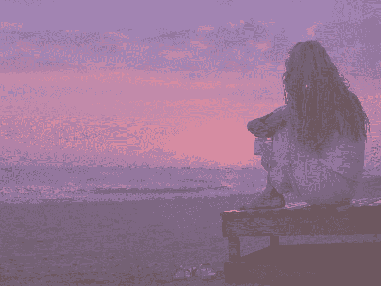 A woman looking at the sunset representing Signs of Low Self Esteem