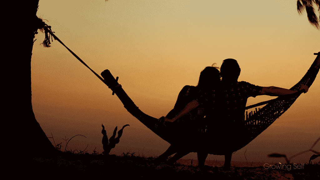 Couple sitting on a hammock at dusk representing Attachment Style Quiz | What's Your Attachment Style?