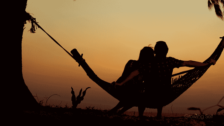 Couple sitting on a hammock at dusk representing Attachment Style Quiz | What's Your Attachment Style?