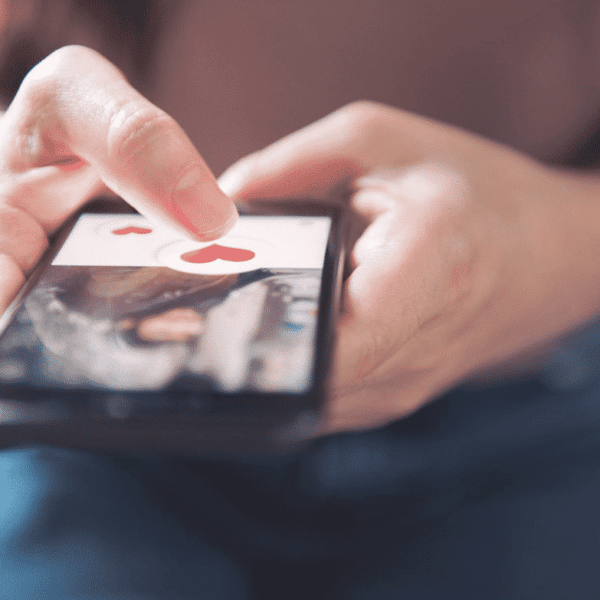 Person on their phone looking at an online dating profile. how to be successful online dating.
